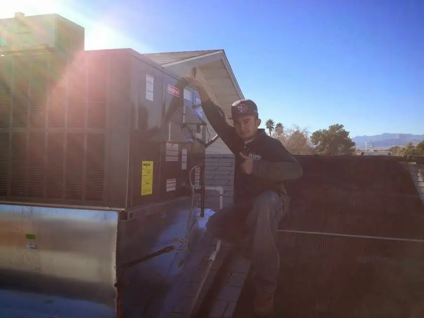 HVAC technician performing Air Duct Cleaning on a rooftop unit in Middle Valley